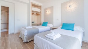 A hotel room with two beds, a wardrobe, and a wall-mounted light fixture. - BLUESEA Don Jaime (Son Servera)