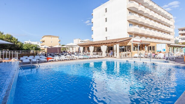A swimming pool with lounge chairs and umbrellas, surrounded by buildings. - BLUESEA Don Jaime (Son Servera)