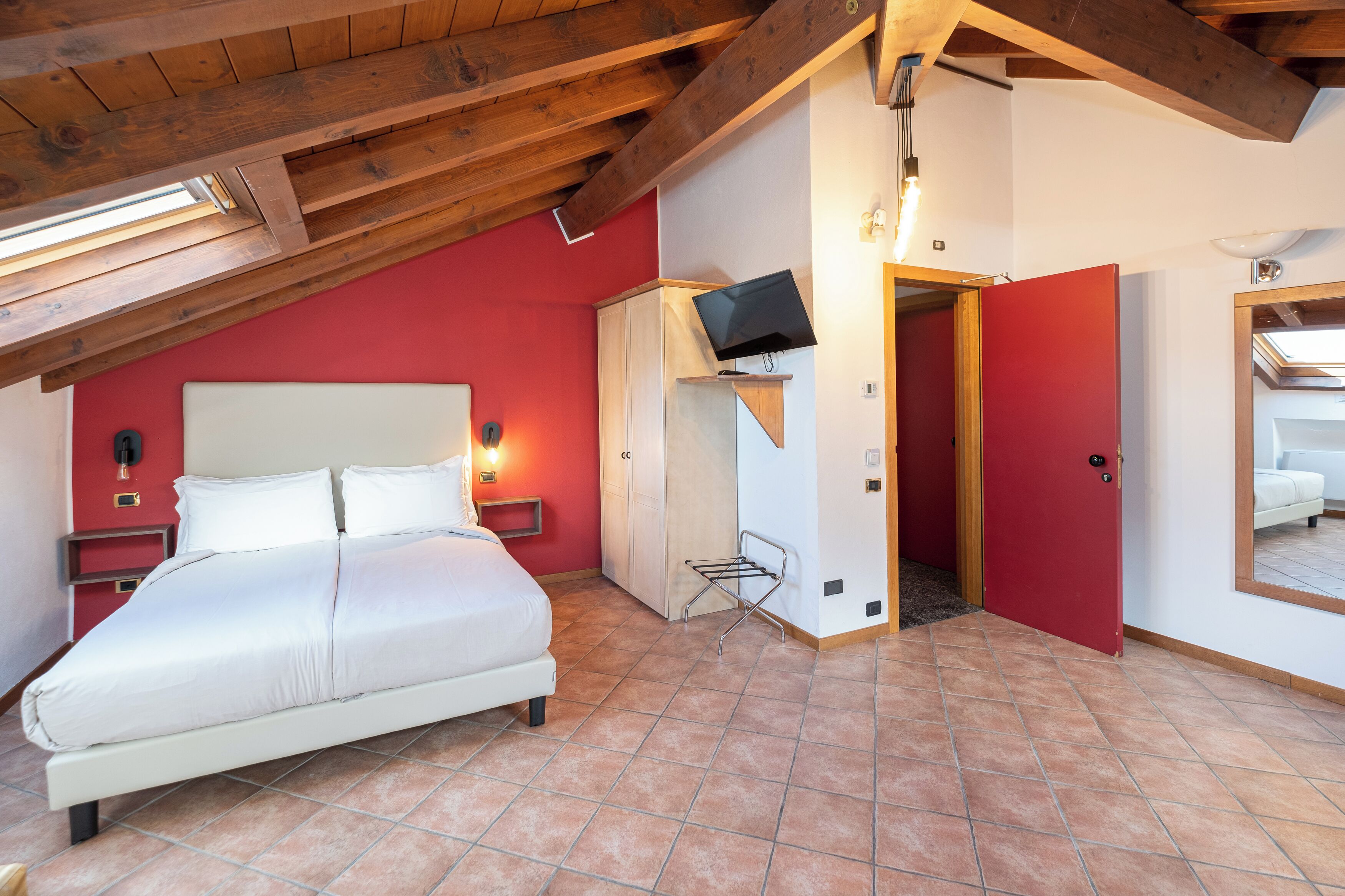 A bedroom with a bed, a TV, and a wardrobe.