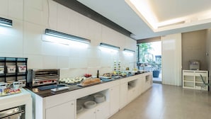 Una cocina moderna con una encimera larga, electrodomésticos integrados y vistas al exterior.