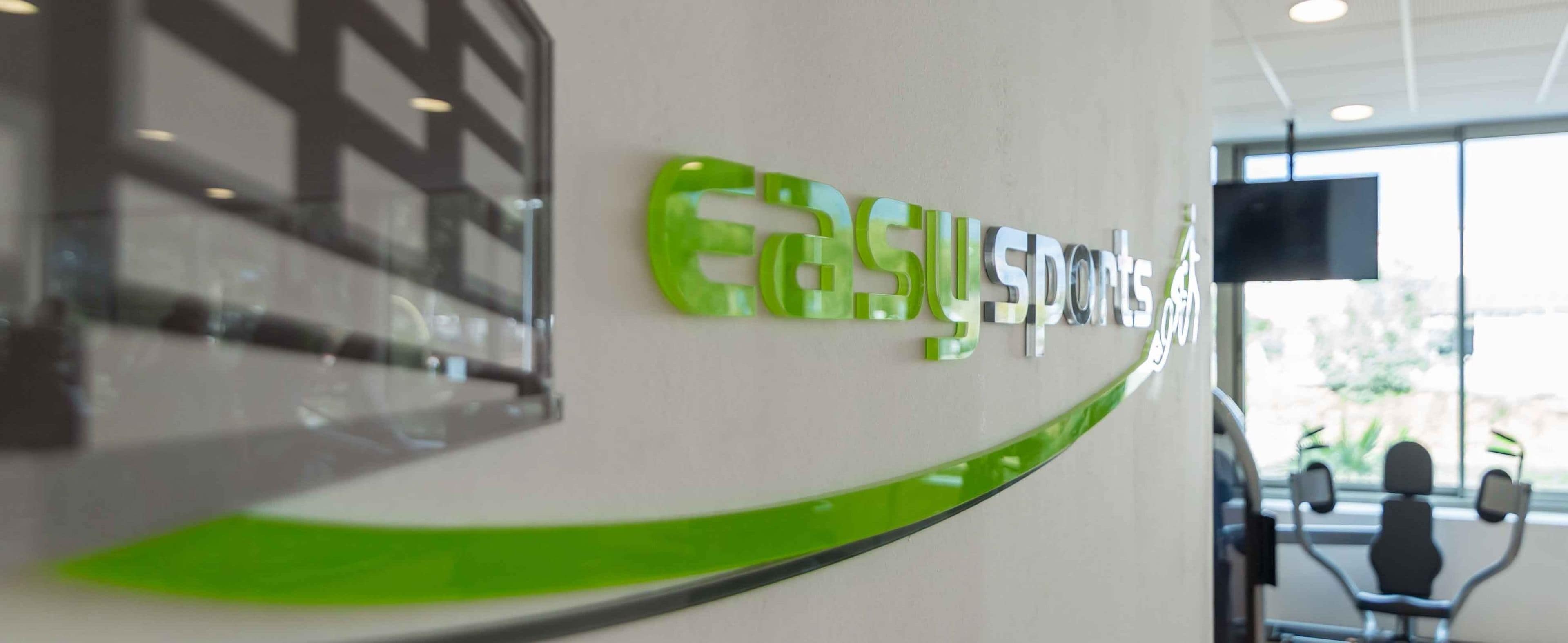 Eine Wand mit den Schriftzügen 'easy sports' in grüner Schrift.