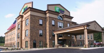 A Holiday Inn Express building with a stone facade, a covered entrance, and an American flag.