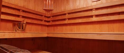 Una sauna con paredes de madera, un banco y un calentador.