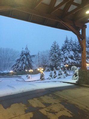 A covered outdoor area with snow-covered trees and a stone wall. - Diego de Almagro Coyhaique (Coyhaique)