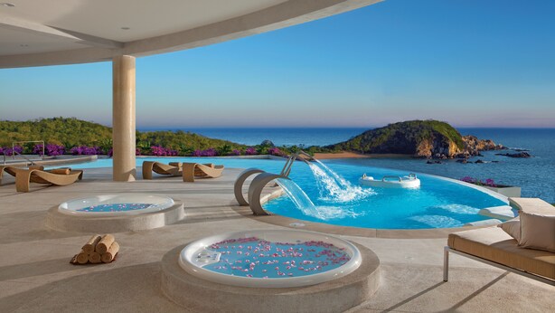 Ein luxuriöser Poolbereich im Freien mit Meerblick, einem Whirlpool und Liegemöglichkeiten.