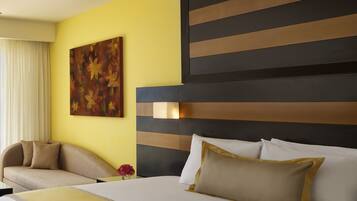 Een hotelkamer met een groot bed, een bank, een schilderij en een raam met gordijnen.