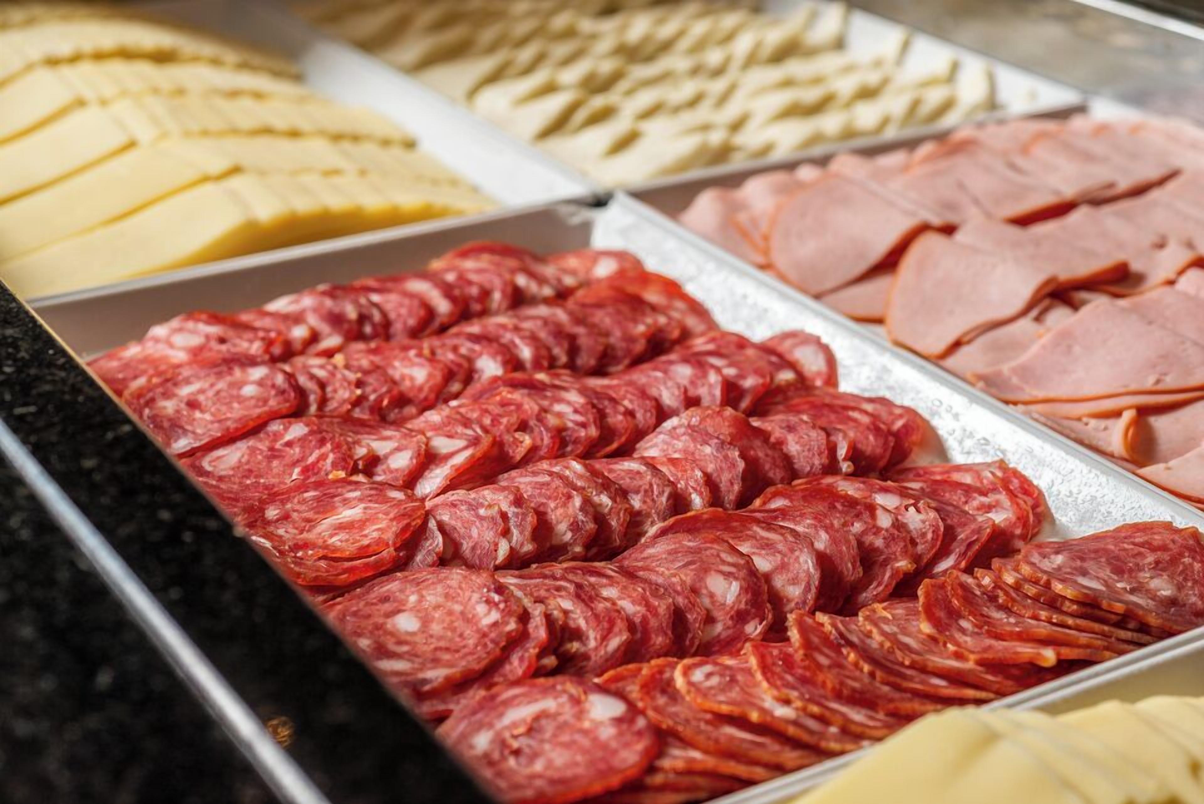 A variety of sliced meats and cheeses on display.