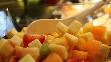 Un tazón de ensalada de frutas variadas con una cuchara.