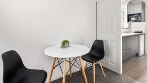 A modern kitchen with white cabinets, a microwave, and a sink. - Ashleigh Court Motel (Rotorua)