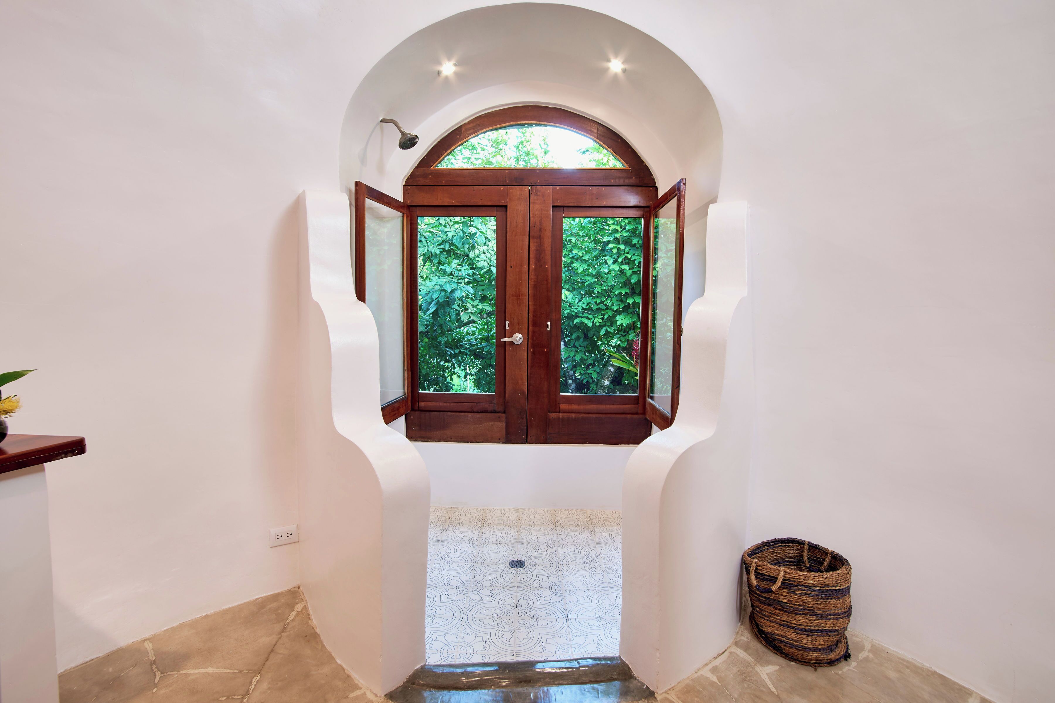 Un pasillo con una puerta de madera que da a un jardín.