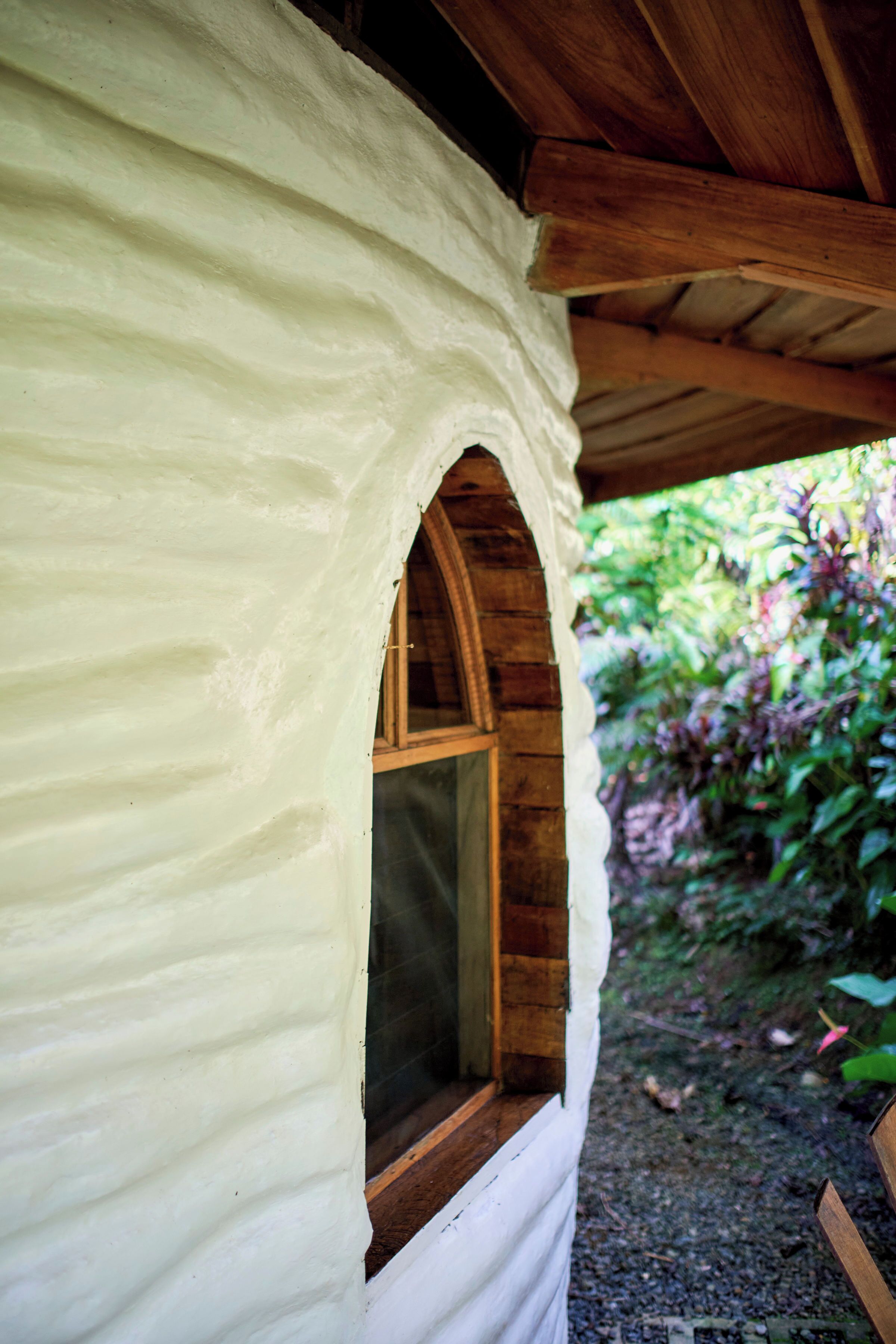 A rustic cabin with a wooden window and a white exterior wall.