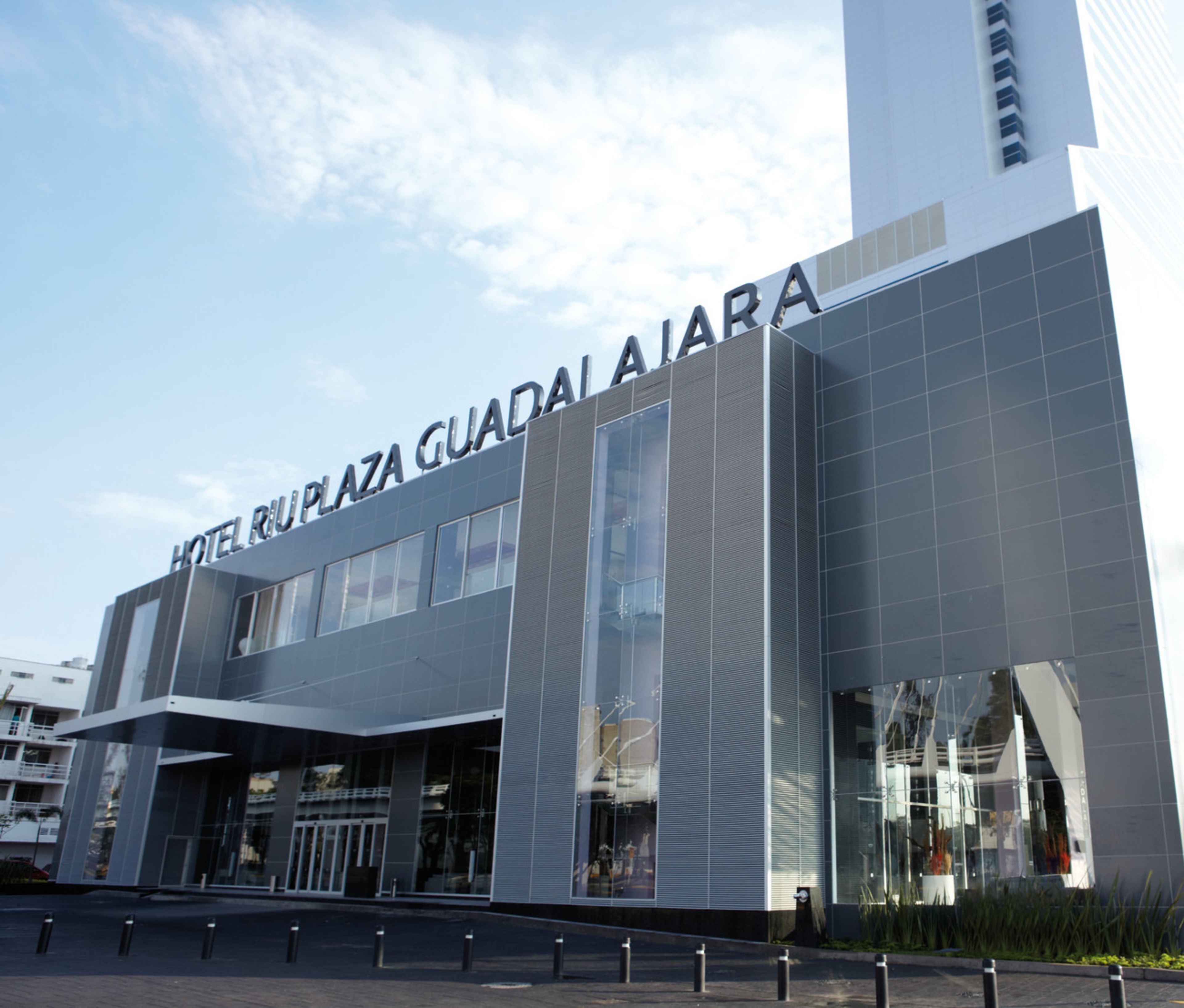 A modern hotel building with a prominent sign reading "HOTEL RUPLAZA GUADALAJARA".