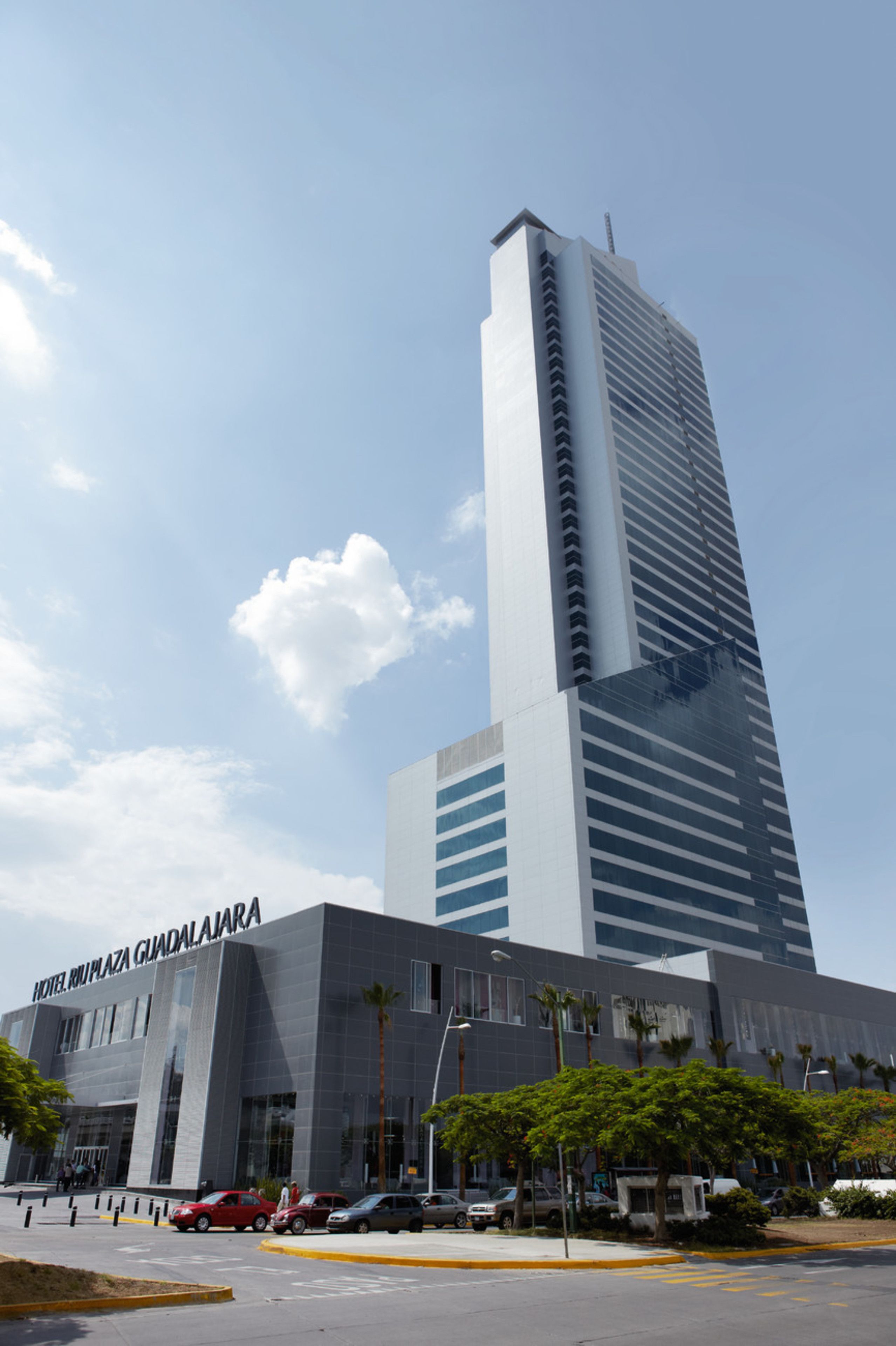 Un moderno edificio de hotel con un diseño vertical llamativo, que presenta un gran letrero en la base.