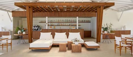 A modern living room with a sectional sofa, wooden coffee table, and a wall-mounted liquor display.