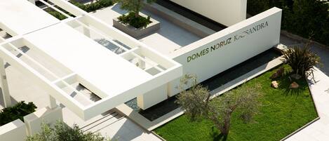 A modern architectural structure with a nameplate reading "DOMES NORUZ KASSANDRA".