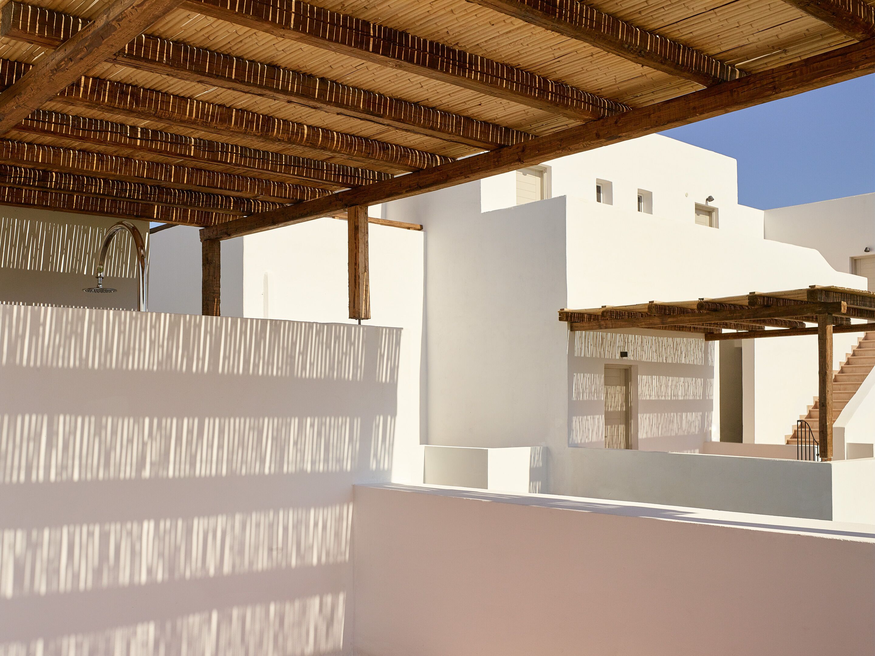 A modern architectural structure with a wooden ceiling and white walls.