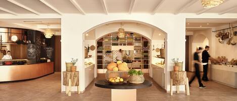 A modern interior with a central island, shelves with various items, and a kitchen area.