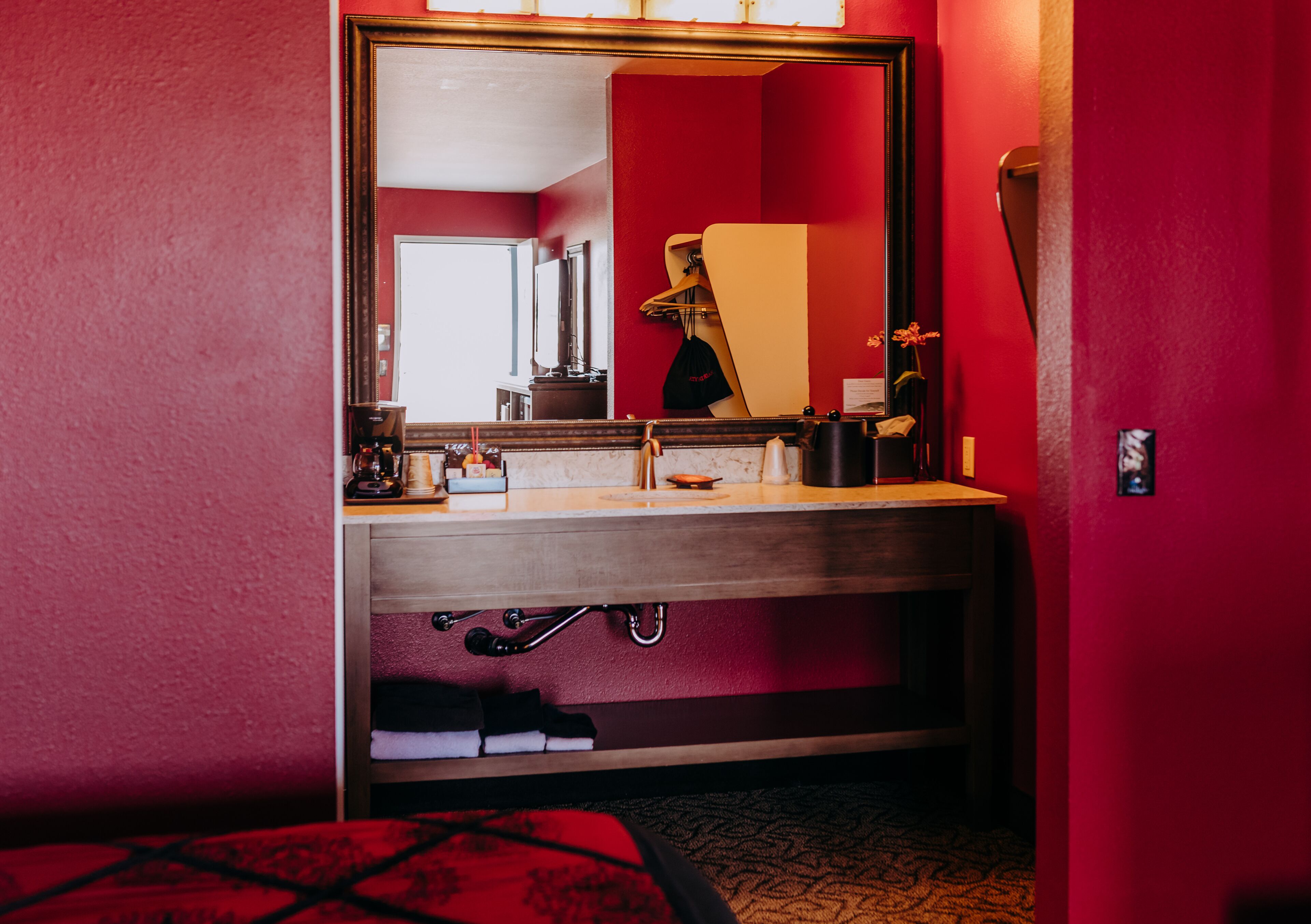 A hotel bathroom with a large mirror, sink, and towel rack.