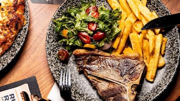 A plate with a steak, fries, and salad.