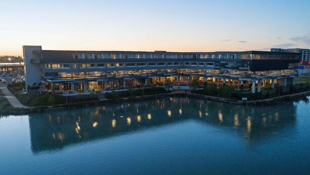 Un hotel moderno con vista al agua, con varios pisos y un patio central.