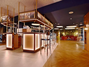 Un espace bar moderne doté d’un plancher en bois, d’un comptoir et de sièges.