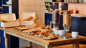 A buffet table with various baked goods and a coffee machine. - ibis Styles Nantes Rezé Aéroport (Reze)