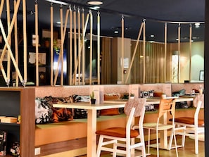 Un restaurante con sillas altas, una barra y decoraciones de cuerda.