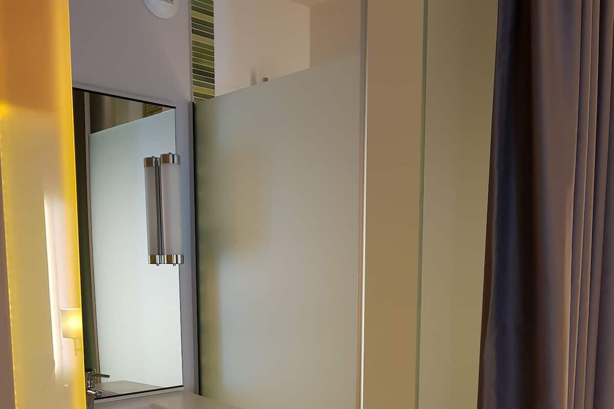 Chambre standard avec 2 lits simples | Salle de bain | Ensemble douche/baignoire, articles de toilette écologiques