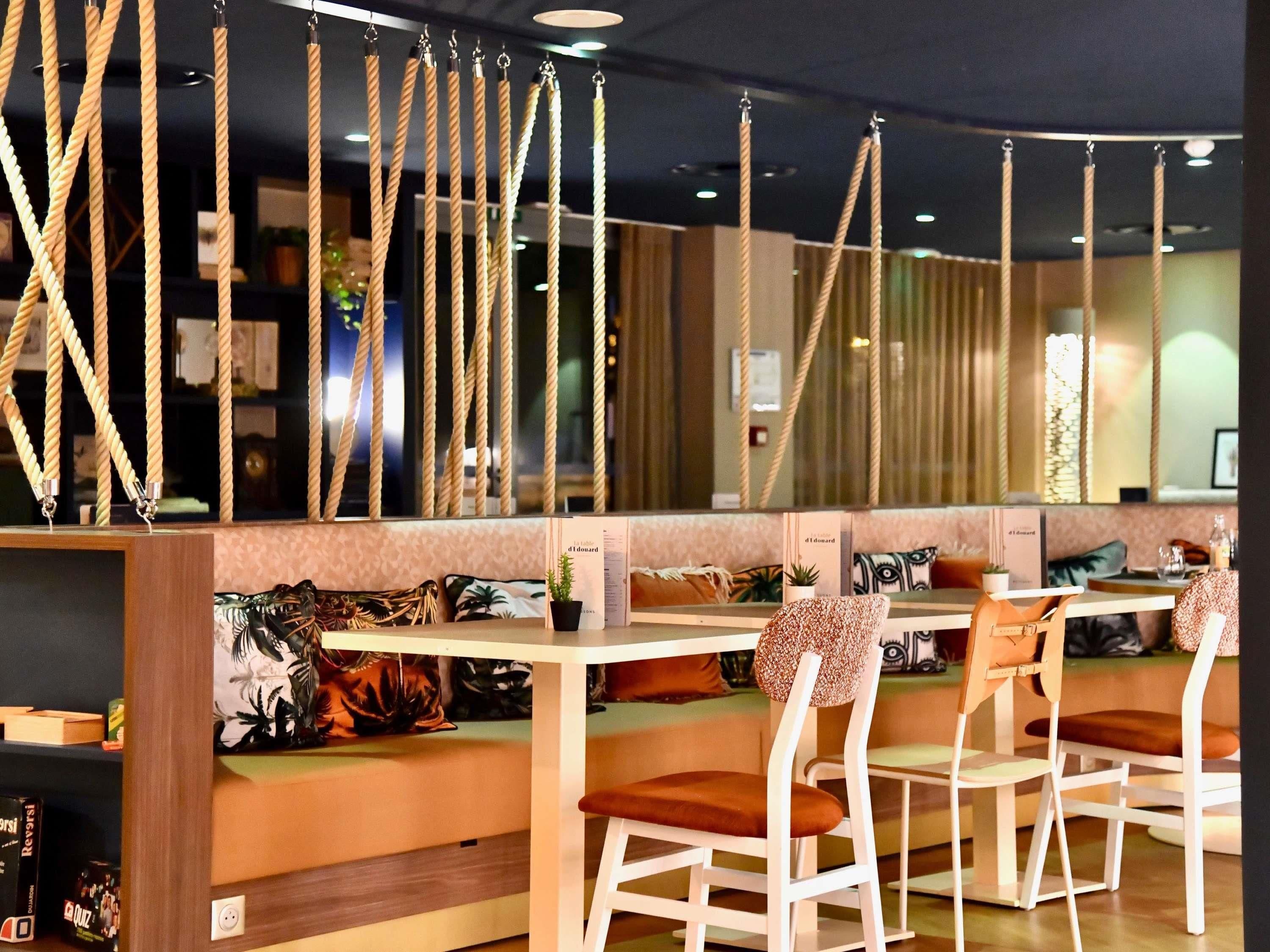 A restaurant with high chairs, a counter, and rope decorations.