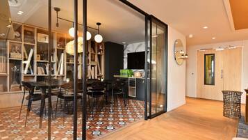 A modern interior with a dining area, a kitchen, and a living space with a large mirror and sliding doors.