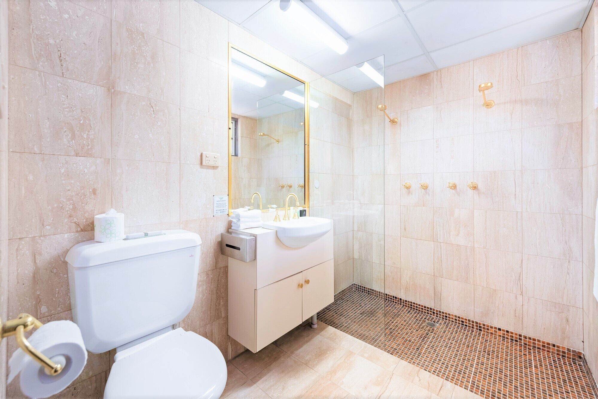 A modern bathroom with a toilet, sink, and shower.