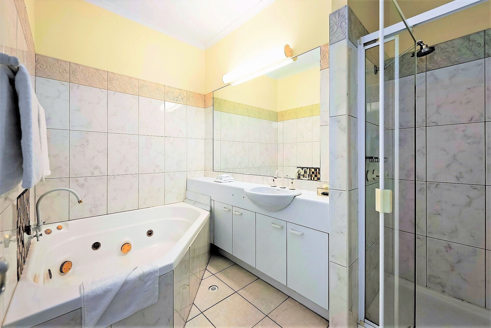 Ein Badezimmer mit einer Badewanne, einem Waschbecken und einer Duschkabine aus Glas.
