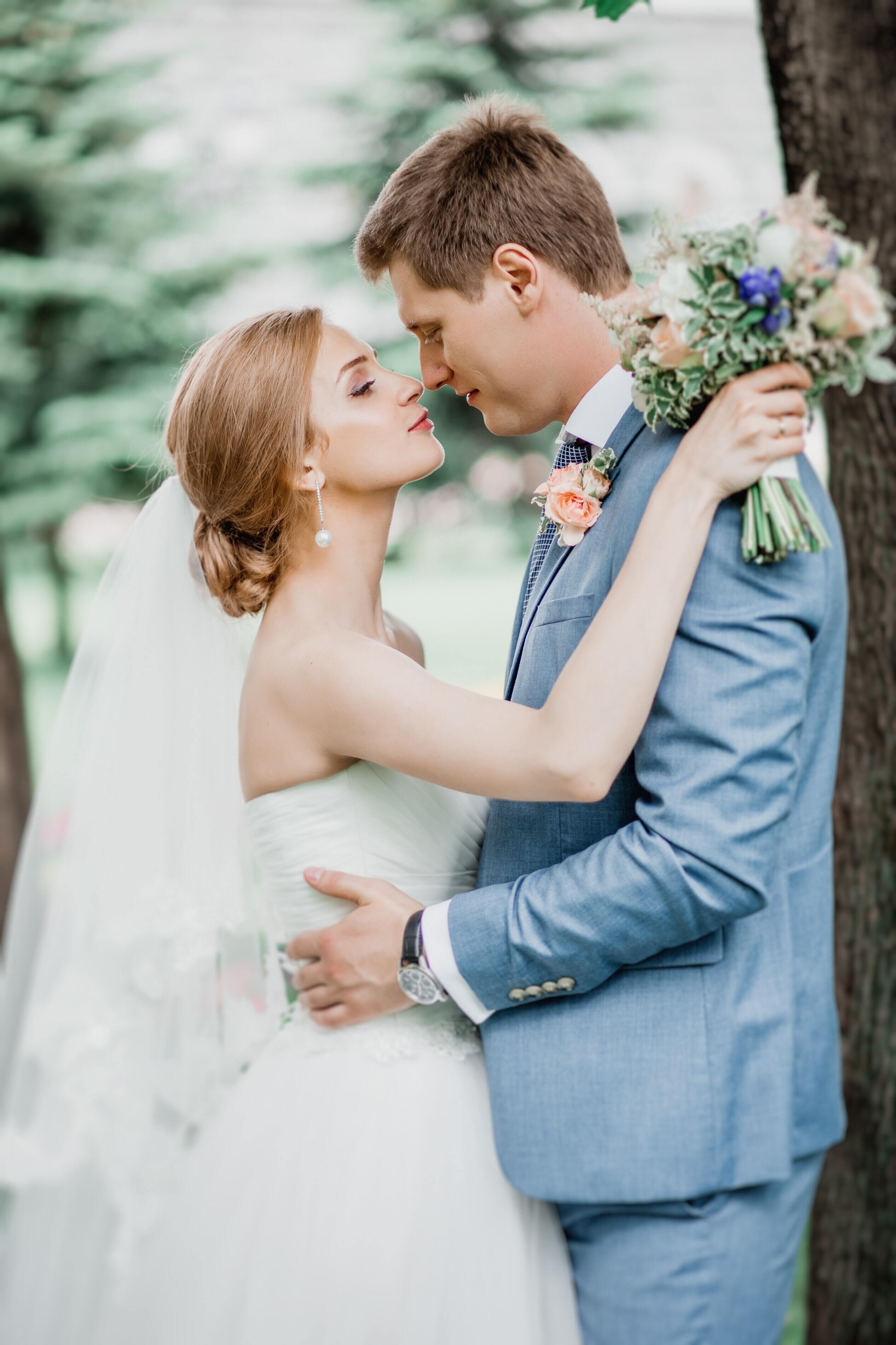 A couple embracing, with the man holding a bouquet.