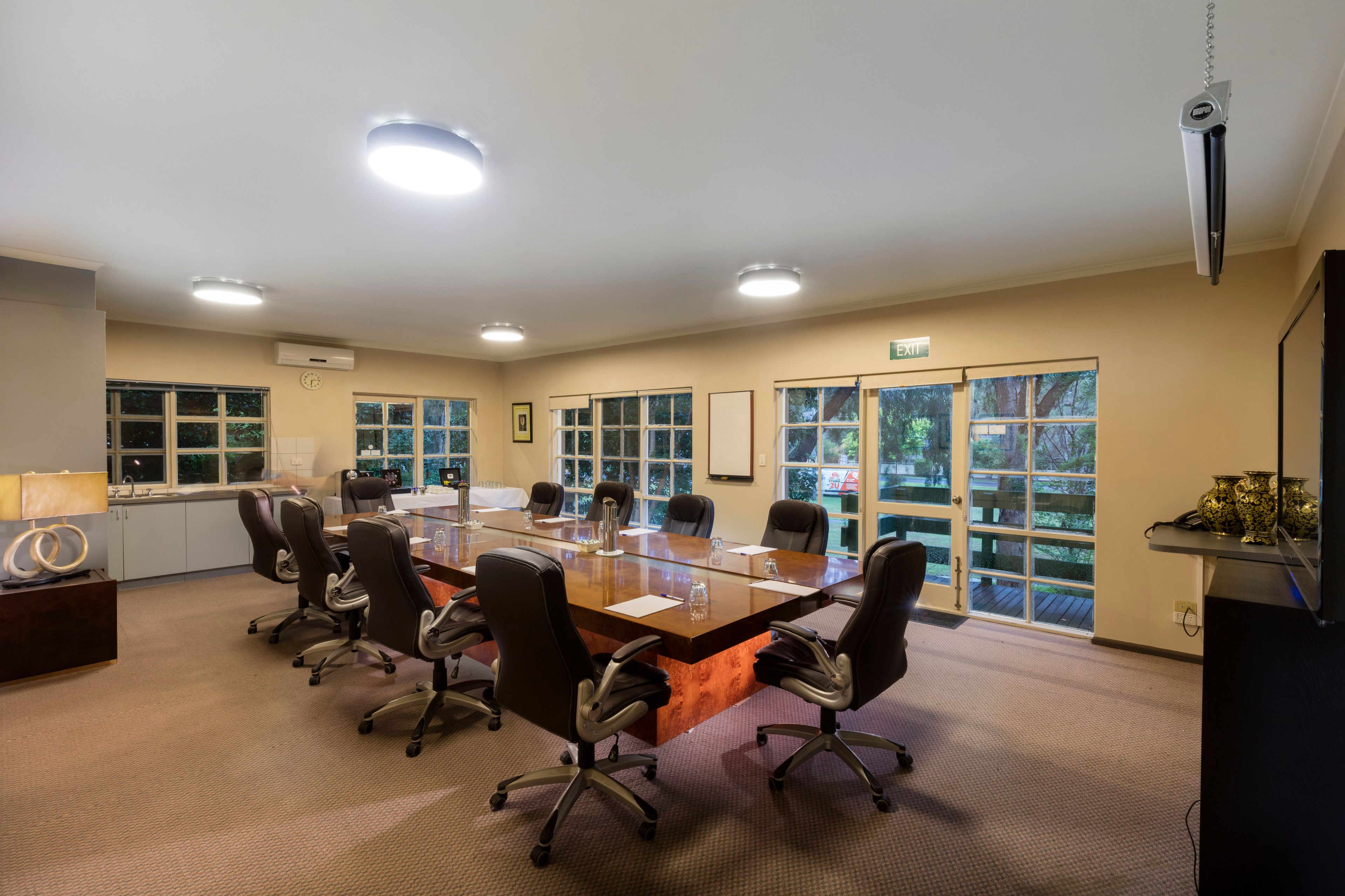A conference room with a long table, chairs, and large windows.