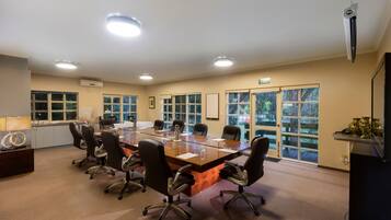 A conference room with a long table, chairs, and large windows.