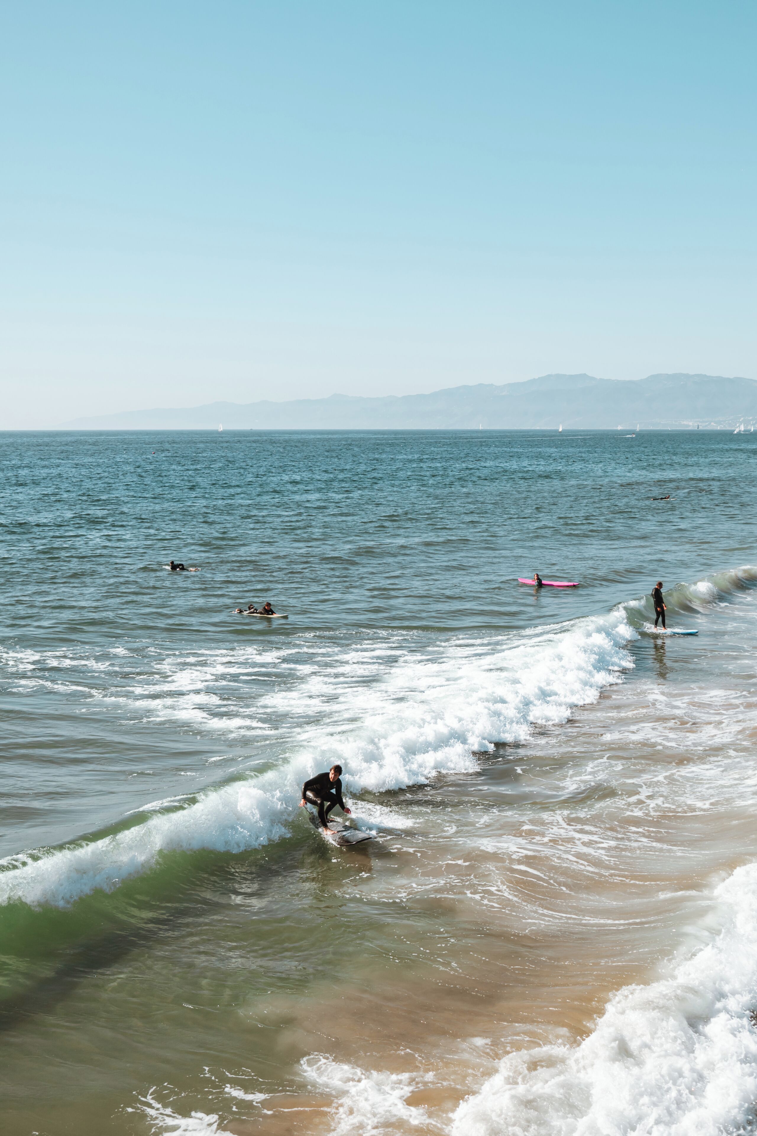 A beach scene with waves and surfers.