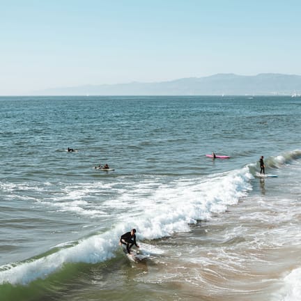 A beach scene with waves and surfers.