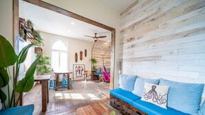 Un salon chaleureux avec un canapé bleu, une table basse en bois et un coin repas comprenant une table et des chaises.
