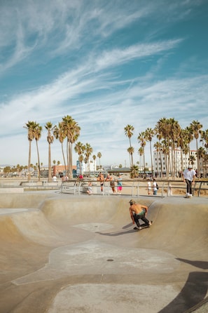 A skate park with ramps and a person skateboarding.