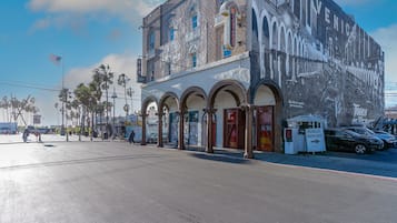 A building with a large mural, arched windows, and a sign for public parking.