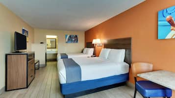 Una habitación de hotel con una cama, un escritorio, una silla, un televisor y un baño.