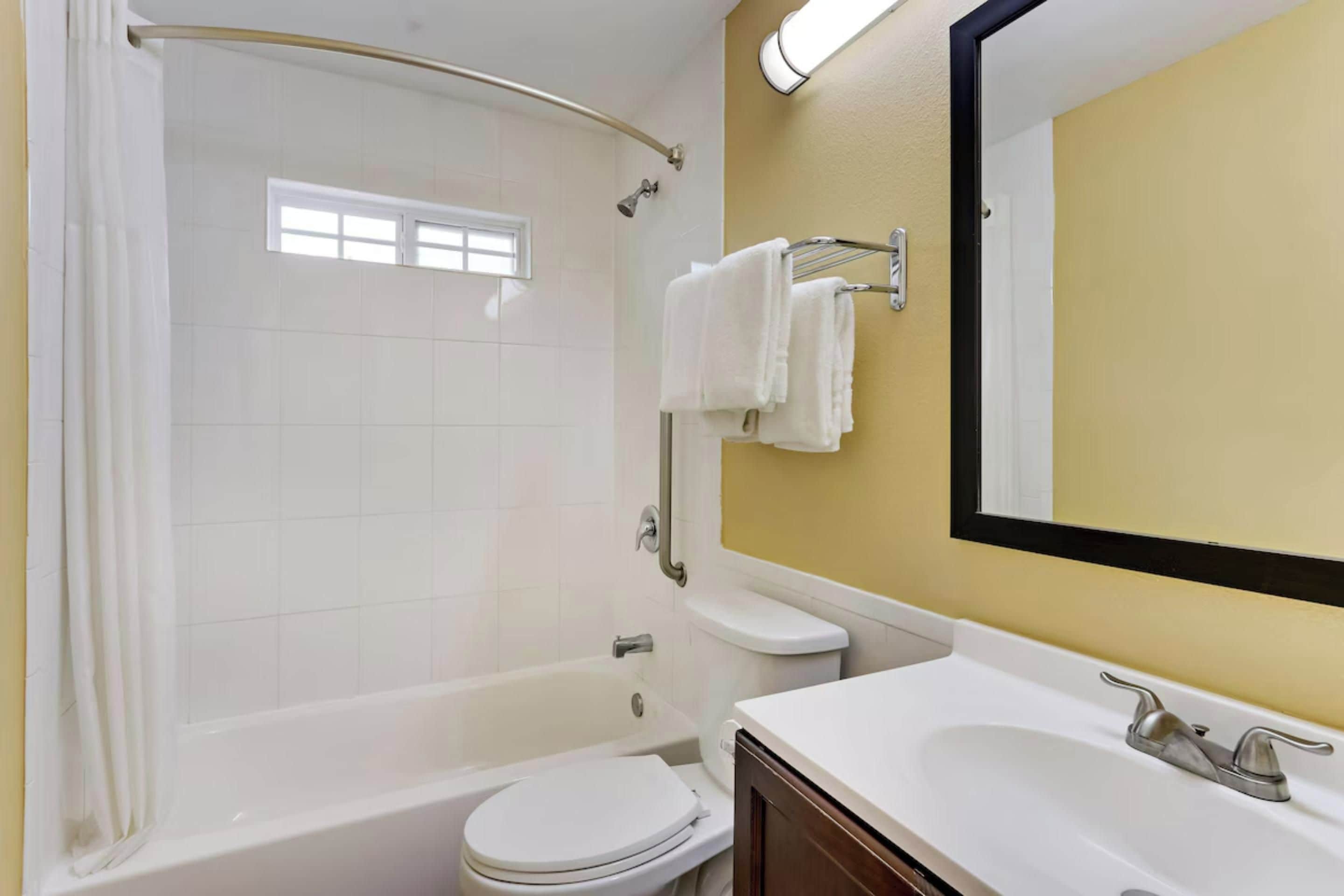 Un baño con bañera, inodoro y lavamanos.