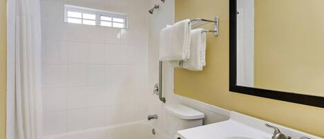Un baño con bañera, inodoro y lavamanos.