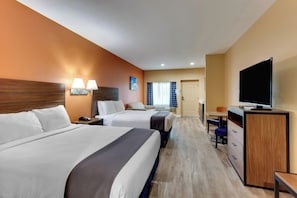 A hotel room with two beds, a desk, a television, and a bathroom visible in the background. - Captains Quarters Inn Port Aransas TX (Port Aransas)