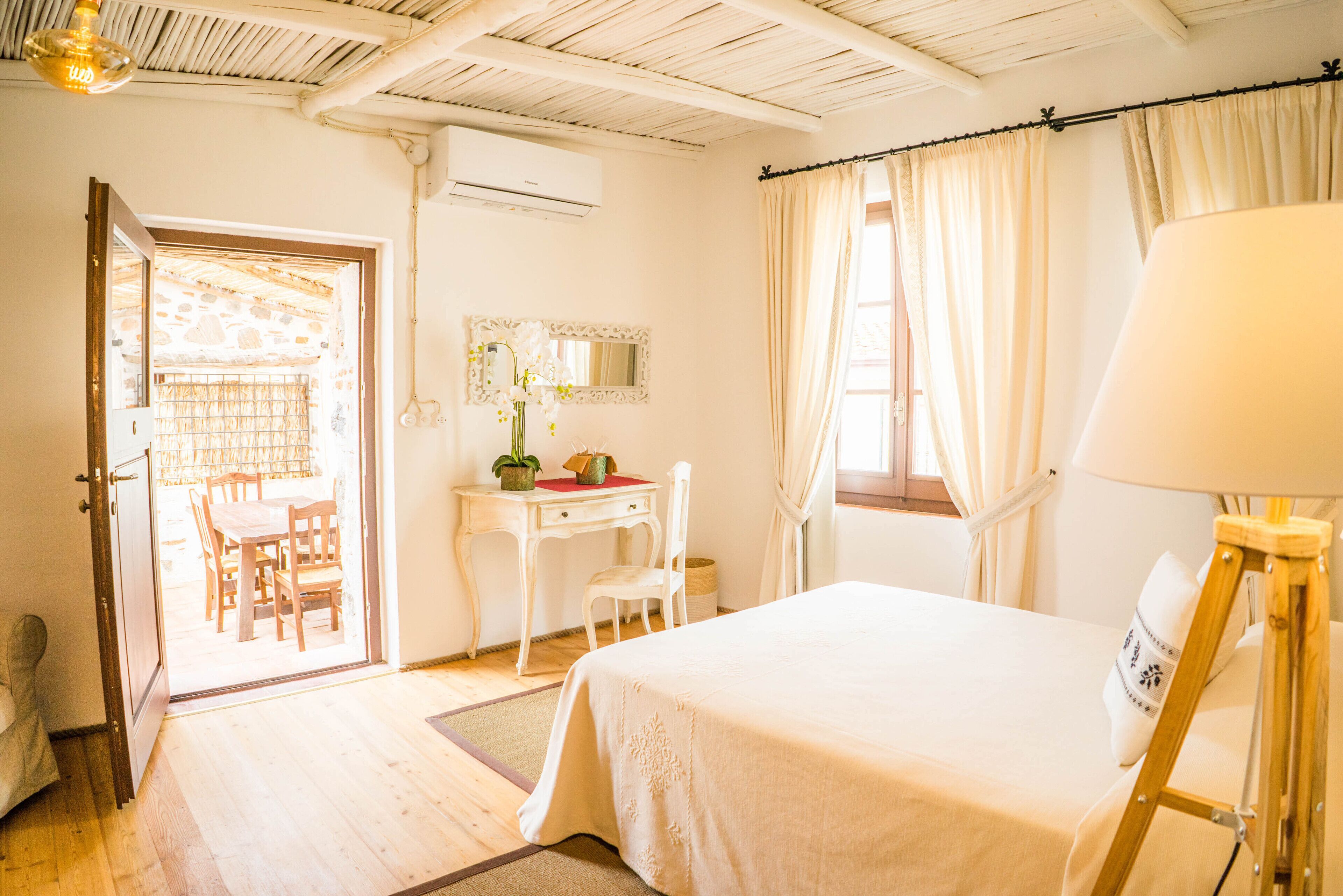 Un dormitorio con cama, escritorio, silla y lámpara.
