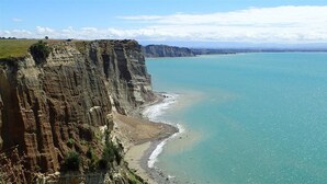 Un paisaje costero con un acantilado y una playa.