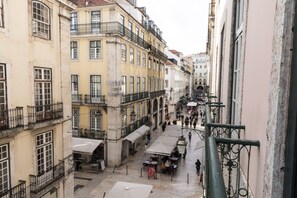 Ein Hotel mit Außenplätzen, einer überdachten Terrasse und Blick auf die Straße.