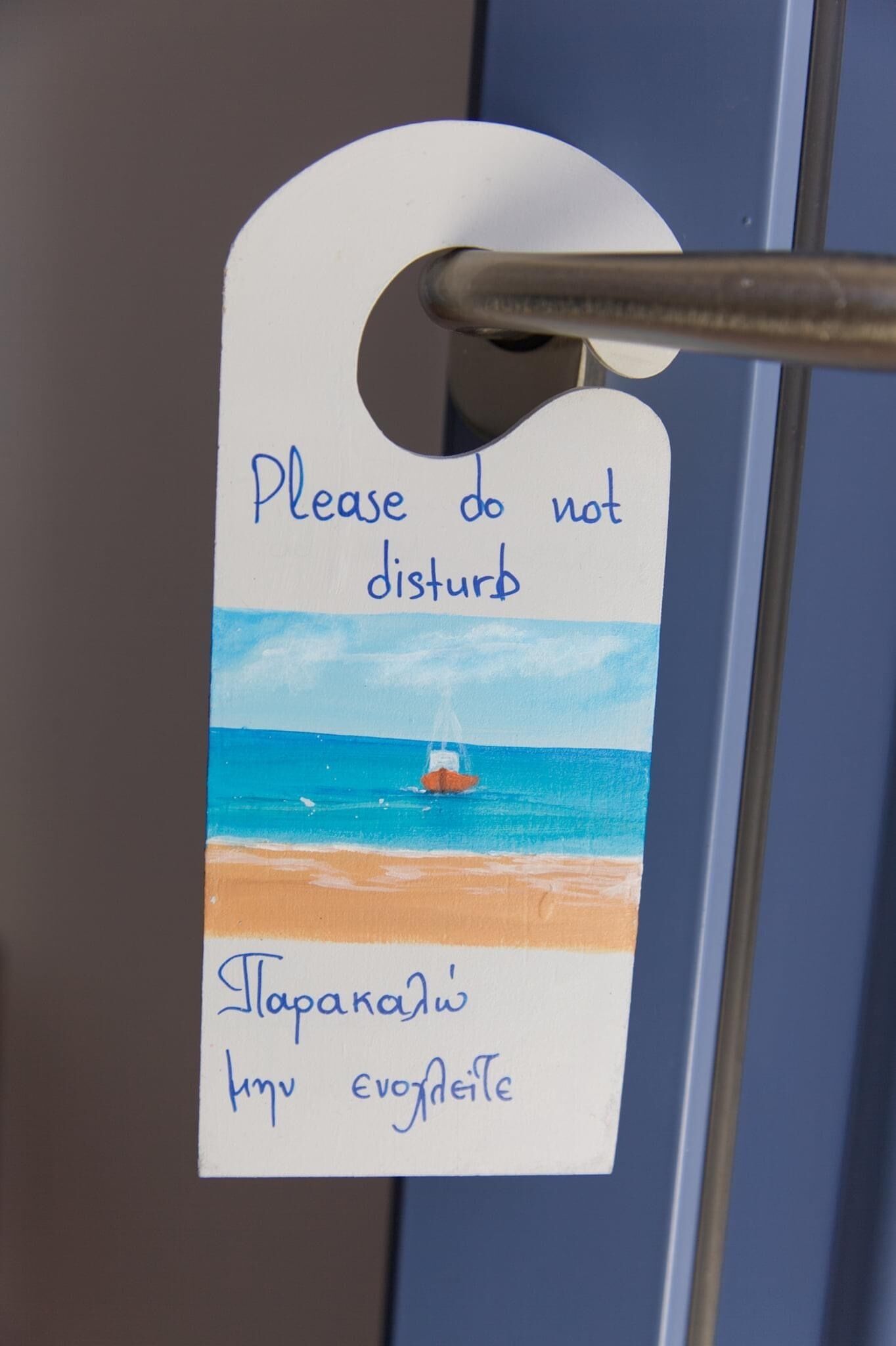 Une étiquette portant un message en anglais et dans une autre langue, fixée à une poignée de porte.