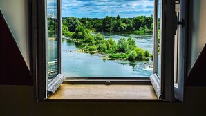 An open doorway with a view of a river and greenery. - Le Relais Louis XI (Meung-sur-Loire)