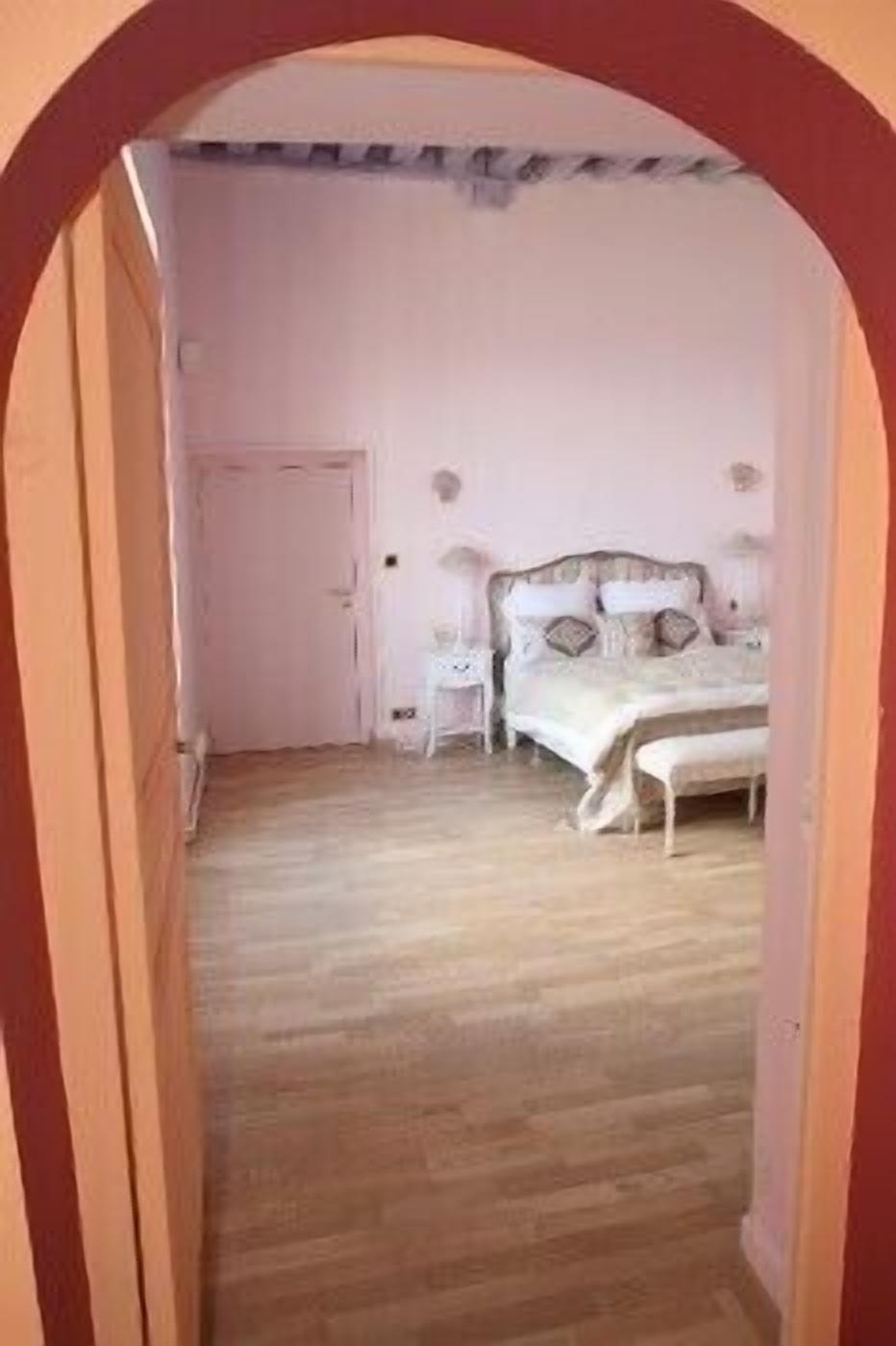 A bedroom with a bed, bedside tables, and a door.